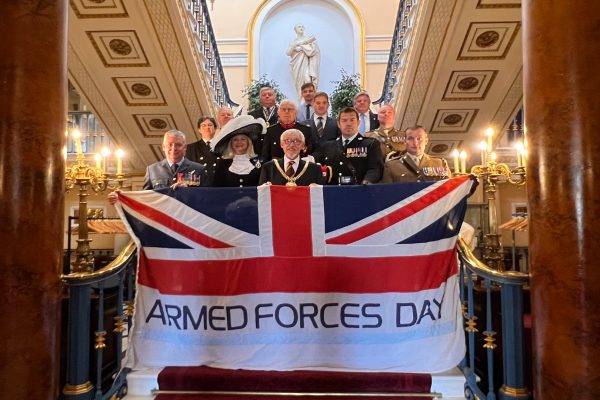 Lord Mayor and Armed Forces personnel holding banner