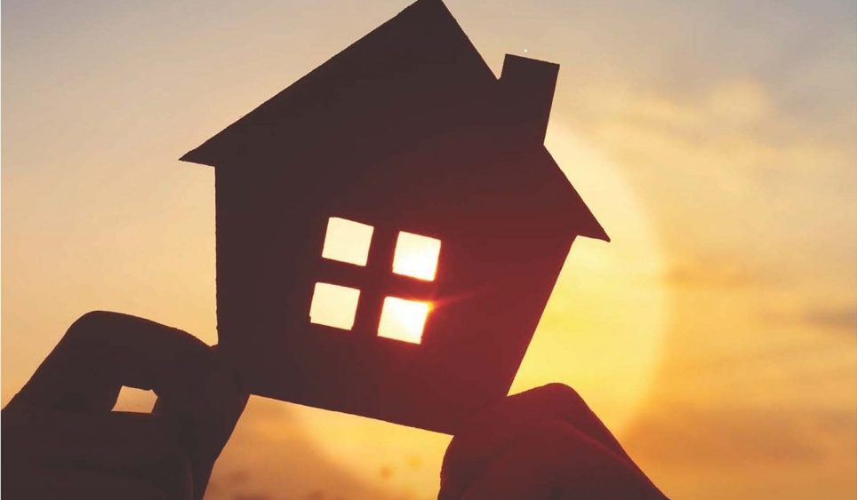 Hand holding cardboard house
